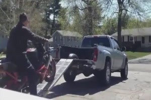 Depp beim Motorrad verladen